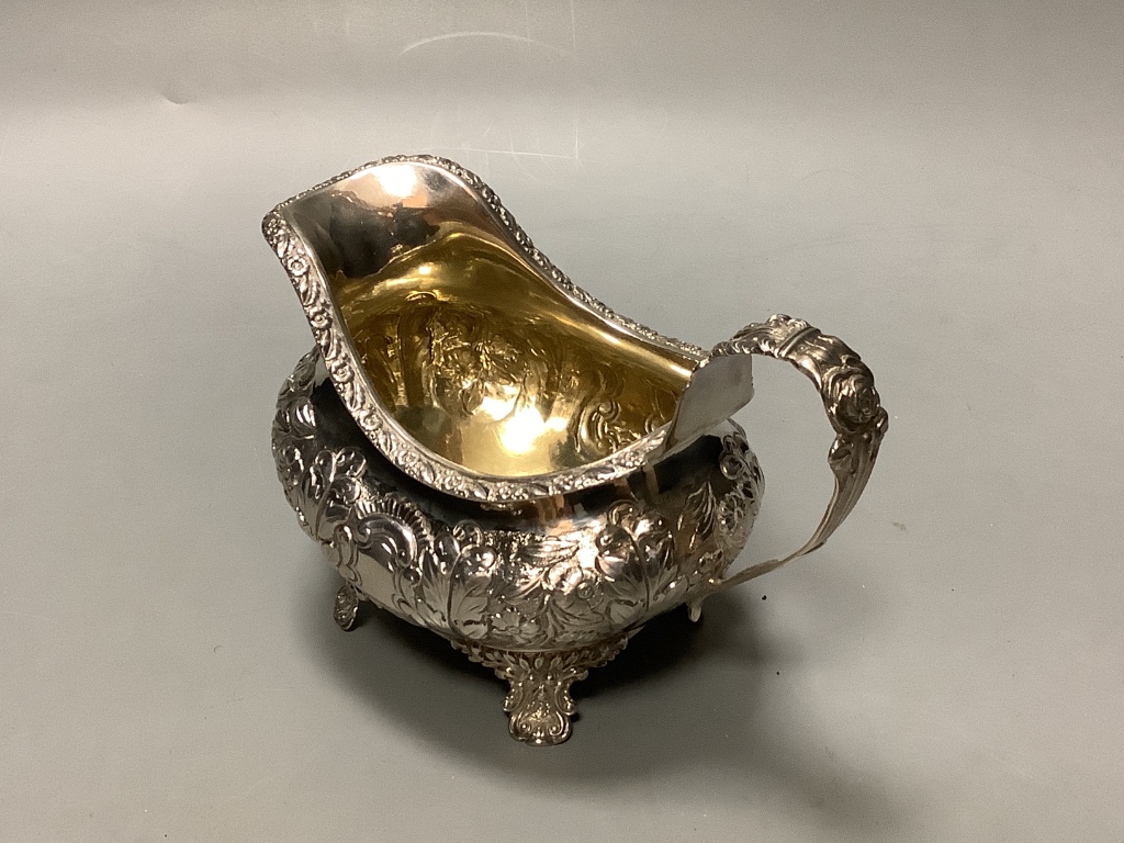 A George the fourth embossed silver cream jug and to handle sugar bowl by Hyam Hyams, London 1824